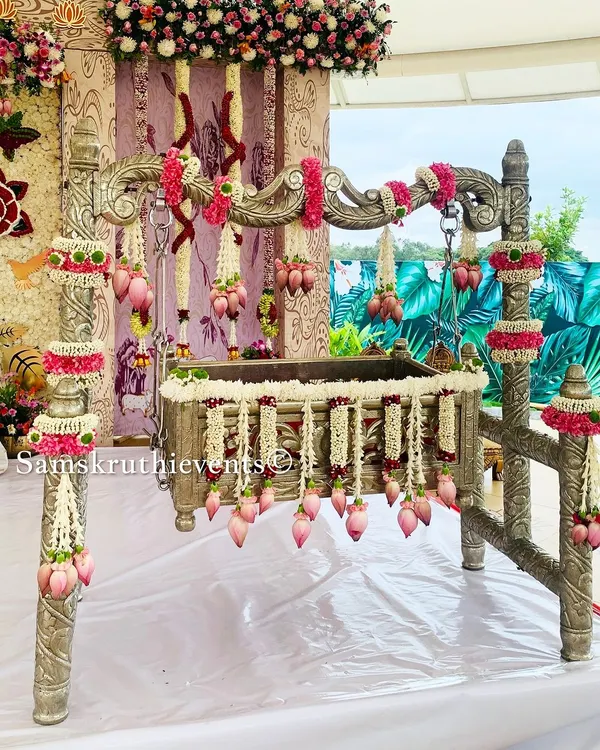 A beautifully decorated silver cradle for a naming ceremony. We've used delicate garlands of jasmine and pink lotus buds to create an elegant and pure look, making the 'Thottilu' a perfect centerpiece.