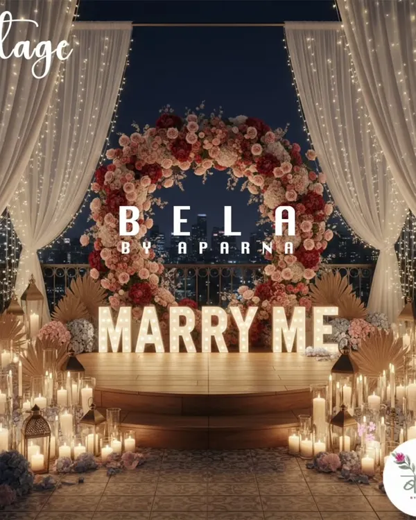 The complete vision for a grand proposal. This rooftop setup includes a custom floral arch, large illuminated 'MARRY ME' letters, and a floor filled with candles, all framed by soft white drapery.