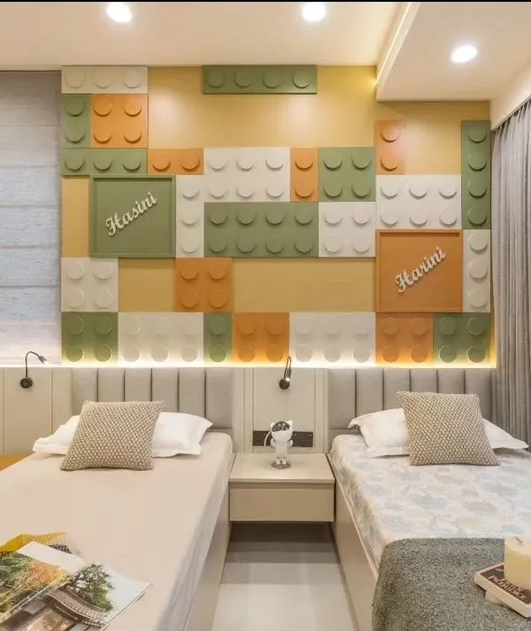 A dream room for any Lego enthusiast! This bedroom features a custom-built wall with colorful, oversized Lego blocks, creating a playful and interactive backdrop for two single beds.