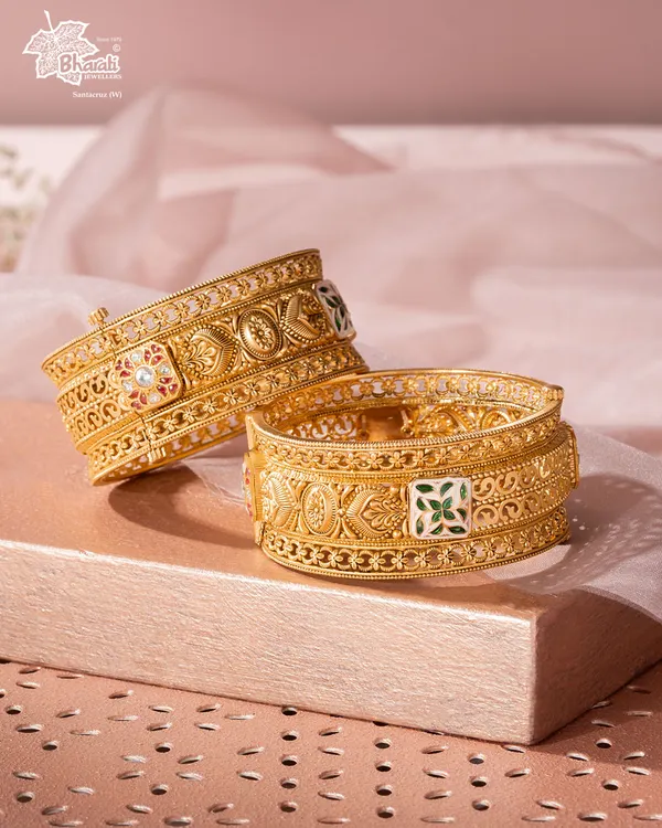 Our Svarn Meenakari Kadas are a fortress of artistry for your wrists. Crafted in 22ct gold, the surface is adorned with intricate filigree and vibrant meenakari (enamel work), translating centuries-old techniques into a masterpiece for the modern collector.