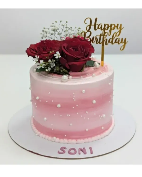 A tall and elegant cake for Soni's birthday. This choco-vanilla cake features a pink ombre design with pearl sprinkles and is topped with fresh red roses.