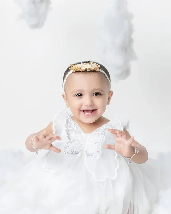 A little fairy with the happiest smile, sitting among the clouds. My studio is equipped with dreamy backdrops and props like these angel wings.