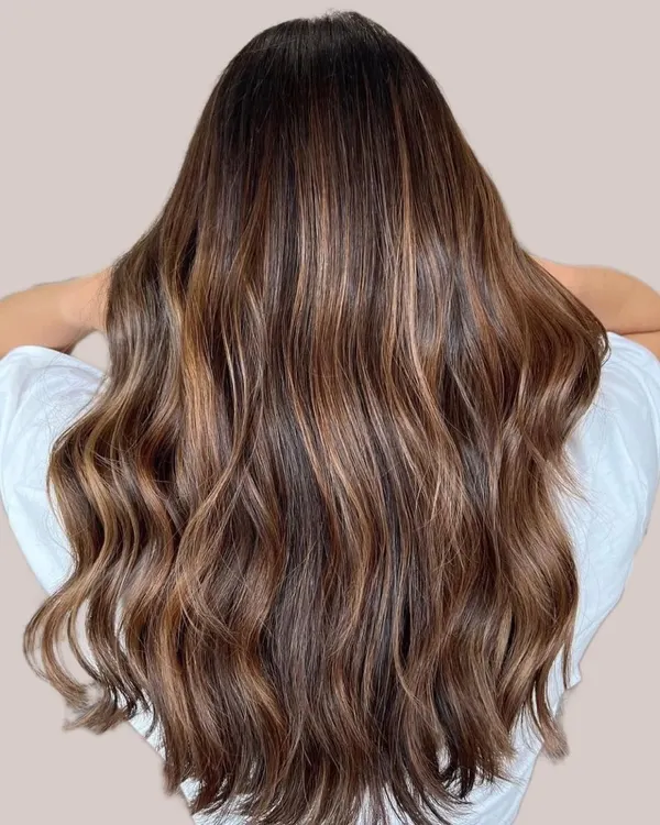 This is the kind of golden warm brunette balayage that makes hair look like it's spun from liquid caramel. I created this look by hand painting seamless highlights to add dimension and incredible shine, resulting in a rich, luxurious finish that glows in any light.