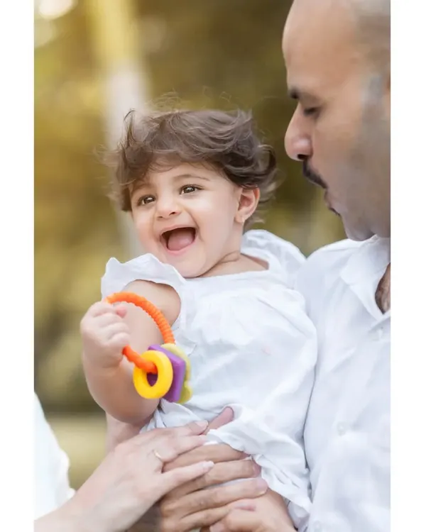 There is nothing more precious than a child's laughter, especially when shared with family. I captured this beautiful, candid moment during a first birthday photoshoot, using the soft natural light to highlight their pure joy.