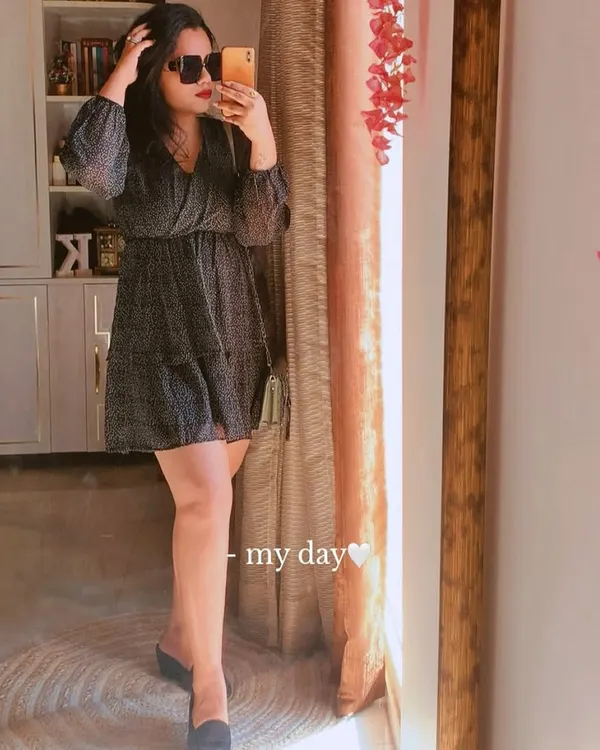 A classic little black dress is a wardrobe essential. This mirror selfie shows a tiered, polka-dot version that's perfect for a weekend outing, styled with simple mules.