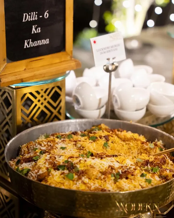 Our 'Dilli-6 Ka Khanna' station, featuring a large pan of aromatic biryani. This counter is a tribute to the legendary street food of Old Delhi, bringing those timeless flavors to your luxury event.
