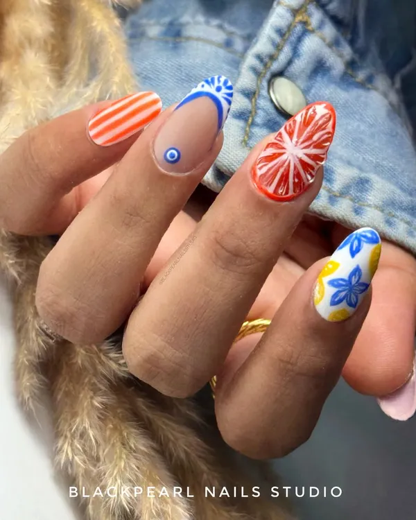 This vibrant set was custom-designed with a Moroccan and citrus theme. It features hand-painted floral and tile patterns, an evil eye detail, and a juicy 3D effect on the orange nails for a truly unique and exotic look.