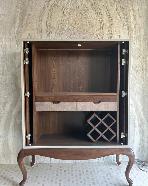 The concealed bar cabinet, shown here with its pocket doors fully retracted. The interior is crafted from warm wood veneer and features a built-in wine rack, drawers, and a pull-out counter, demonstrating our commitment to maximizing functionality within a compact footprint.