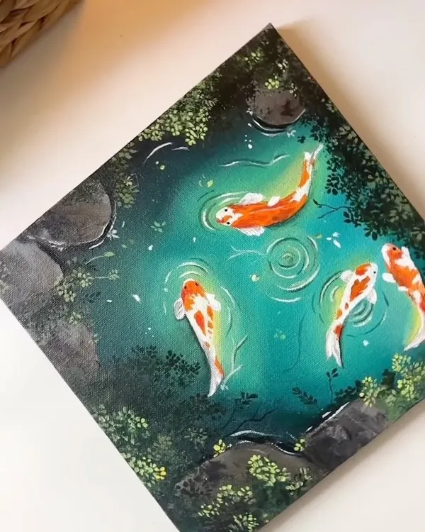 A close up of my finished acrylic painting of a koi pond. I focused on the vibrant orange and white of the fish against the deep teal water, with small ripples showing their gentle movement.