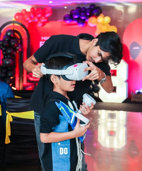 A guest being fitted with a VR headset by our staff member, ensuring a comfortable and safe entry into the world of virtual reality gaming.