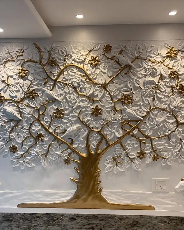 The completed Kalpavriksh mural in a corporate office. The white and gold tree is flanked by two small cow sculptures, adding to the symbolism of prosperity and abundance.