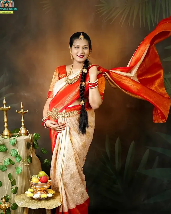 A beautiful portrait of the mom-to-be in a traditional South Indian silk saree. The flowing pallu adds a dynamic and graceful element to this culturally rich maternity photo.