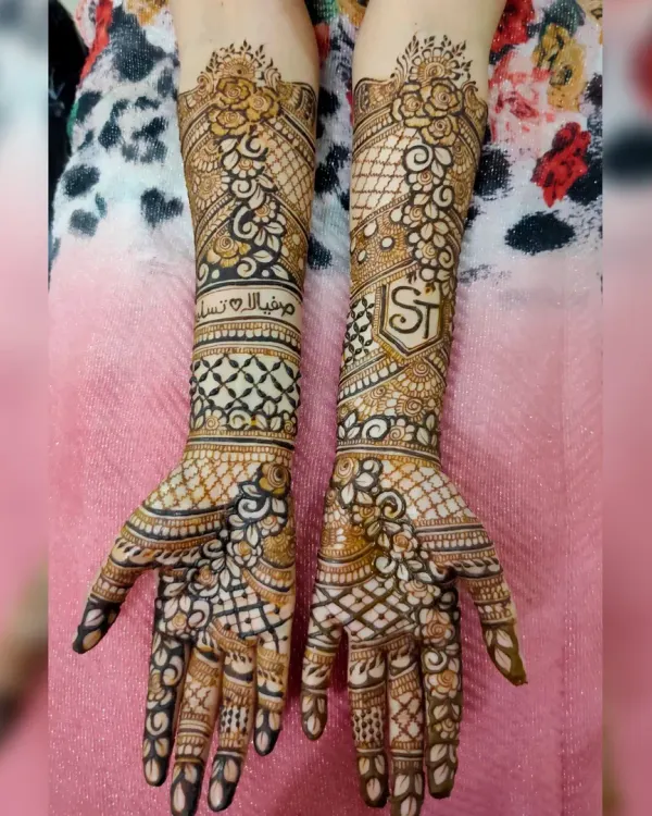 This is the kind of detailed bridal henna I love to do. This design covers the full forearm with a mix of traditional patterns, including a jaal net, floral motifs, and personalized elements like the couple's initials and an Arabic blessing.