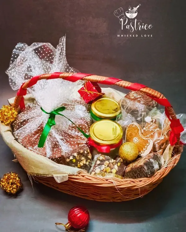 My signature Christmas hamper, thoughtfully curated and wrapped with a festive ribbon. It’s the perfect gift, filled with a variety of my best holiday treats like plum cake, brownies, and fudge.