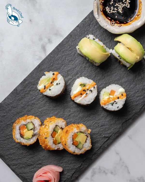 A platter of assorted sushi, including crispy tempura rolls and creamy avocado rolls. We bring the art of Japanese cuisine to your event.
