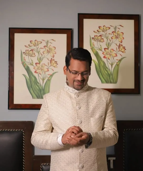 A quiet moment with the groom as he gets ready, adjusting his attire. This portrait captures his calm and anticipation.