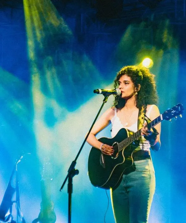 This is me in my happy place, on stage with my guitar, opening for When Chai Met Toast. Performing my original songs like 'Snowflake' for a live audience is a feeling I'll never forget. I love creating these big, memorable moments at concerts and festivals.