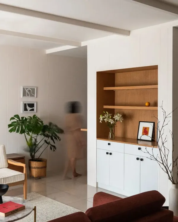 The foyer and living area of Chakma's Home, an apartment interior project. We used a simple palette of white and wood, with clean lines and thoughtful storage to create a calm and uncluttered space.