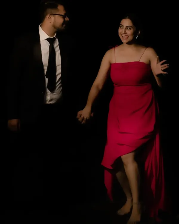 For this pre-wedding shoot, I styled the couple in a classic, high-contrast look. Her custom red dress with an asymmetrical hem brings a pop of color and movement against his sharp, dark suit.