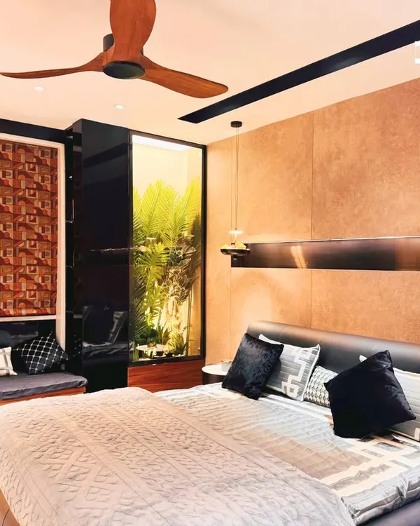 This bedroom is a perfect example of creating a warm, earthy retreat. The design features a leather-upholstered bed, textured wall panels, and a cozy window seat that brings in natural elements.