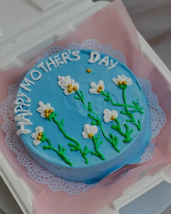 A beautiful blue bento cake for Mother's Day, hand-painted with delicate white flowers. These mini cakes are perfect for showing someone you care.