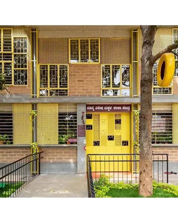The vibrant facade of the Mathru Centre for Developmental Disabilities in Bengaluru, made entirely from reclaimed windows painted bright yellow. The design creates a cheerful and welcoming landmark while demonstrating our commitment to resource circularity.