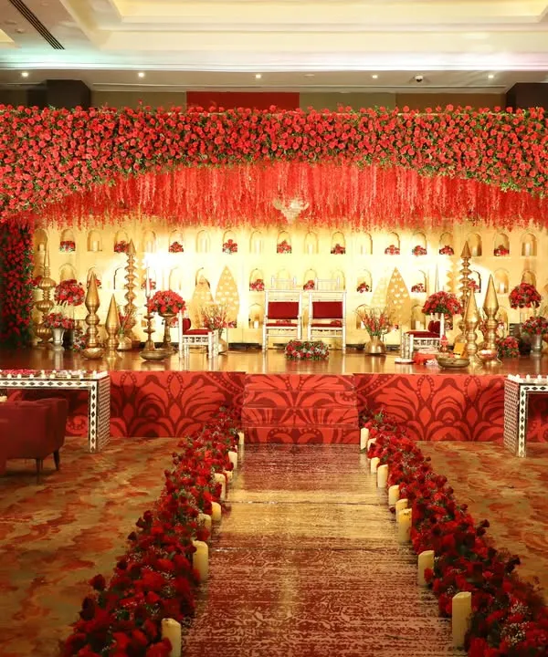 I believe every couple deserves a royal stage. For this reception at NESCO, I designed a breathtaking backdrop with a cascade of red roses and opulent gold accents, creating a space that felt both grand and deeply romantic.