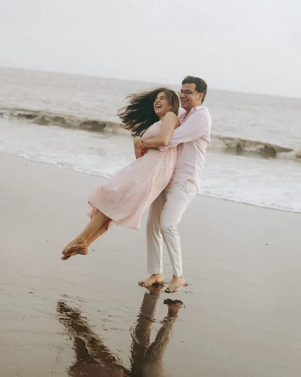 A moment of pure, carefree joy. I asked him to lift her, and the resulting laughter and movement against the ocean backdrop created this beautiful, spontaneous portrait of Ritu and Tarush.