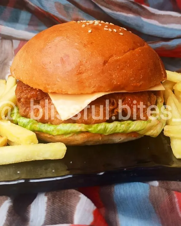 My homemade Chicken Zinger Burger is a complete meal, featuring a perfectly fried chicken patty with cheese and lettuce, plated with crispy fries.