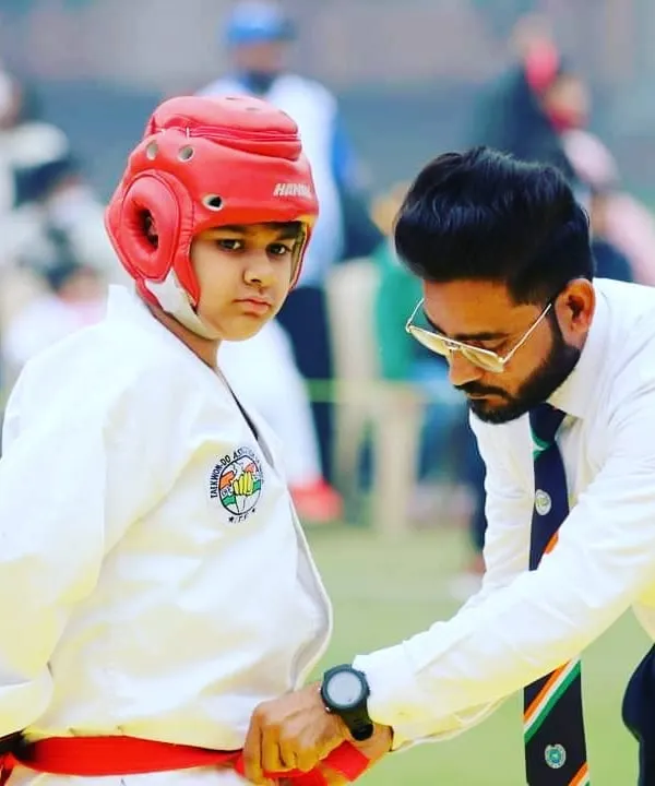 I believe in hands on coaching, especially during competitions. Here, I am making sure my student is focused and ready before his sparring match begins.