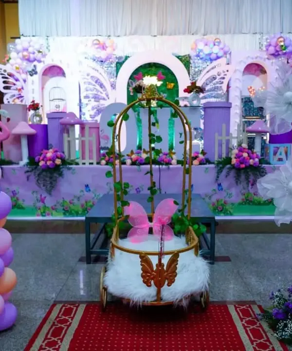 A fairy tale come to life with this butterfly-themed stage. The centerpiece is a beautiful golden cage for the birthday girl, surrounded by pastel balloons and whimsical props.