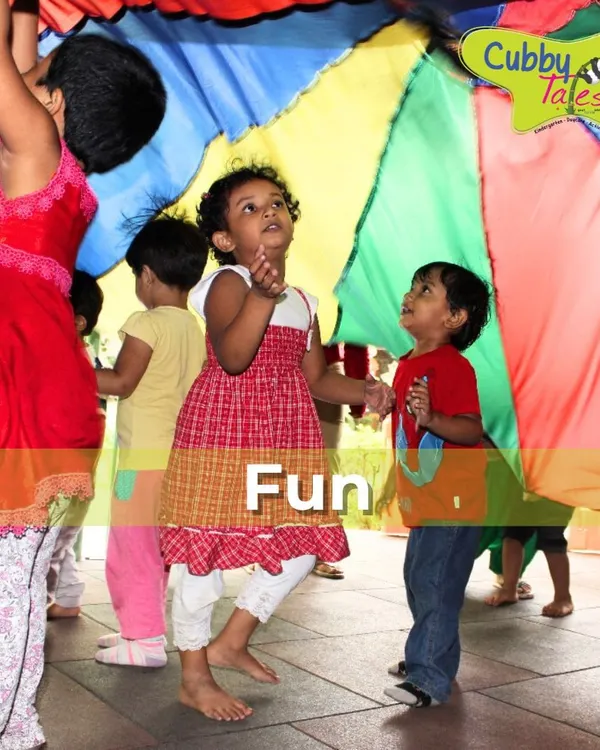 The parachute game is a perfect activity for promoting teamwork and gross motor skills. The children's faces light up with excitement as they work together to make colorful waves, learning to cooperate in the most joyful way.