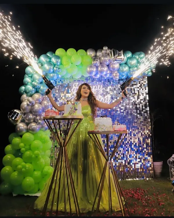 We create unforgettable moments with dramatic setups like this. This birthday celebration features a full shimmer wall backdrop, custom balloon arrangements, and cold pyro guns for a truly spectacular cake-cutting experience.