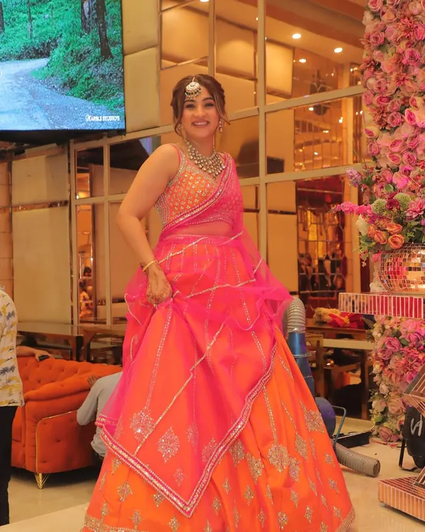 For my brother's wedding, I chose this vibrant orange and rani pink lehenga. It was the perfect balance of delicate mirror work, joyful color, and comfortable volume, allowing me to enjoy the festivities without feeling weighed down. This is what I aim for with all my clients: a look that is both stunning and practical.