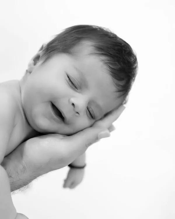 So small, so loved. This classic black and white photo of a newborn resting in their parent's hand is a powerful reminder of how tiny they once were.
