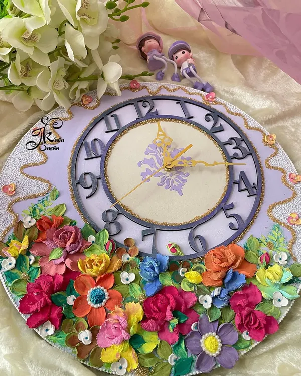 A full view of a 14-inch custom wall clock with a lavender base and a cascade of multi-colored flowers. The unique numeral design adds a modern touch to this floral timepiece, perfect for a bedroom or study.