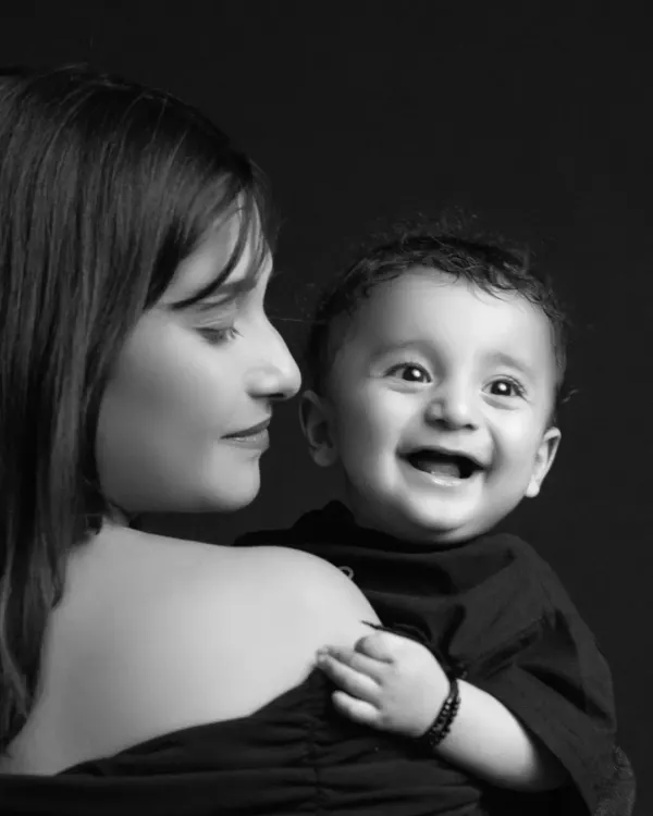 A mother's gentle gaze and a baby's pure, unrestrained laughter. In black and white, this intimate portrait becomes a timeless testament to the joy of motherhood.