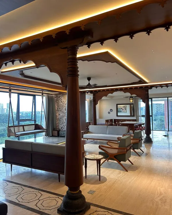 Another view of the Embassy Lake Terraces residence, showing how the traditional wooden structure defines the living and dining areas. The design allows for an open feel while creating distinct zones, with a clear sightline to the oonjal and window views.