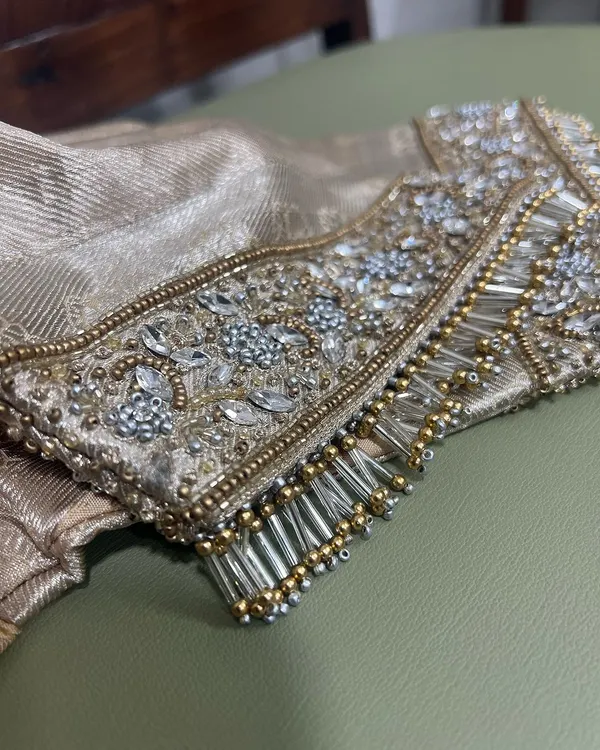 Tassels and crystals. A close-up of a heavily embellished sleeve cuff, featuring intricate crystal work and bugle bead tassels for a touch of glamour.