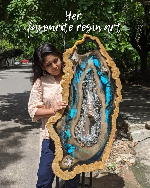 Holding one of my favorite custom geode resin creations. The combination of brilliant blue, earthy tones, and sparkling crystals makes this a true statement piece.