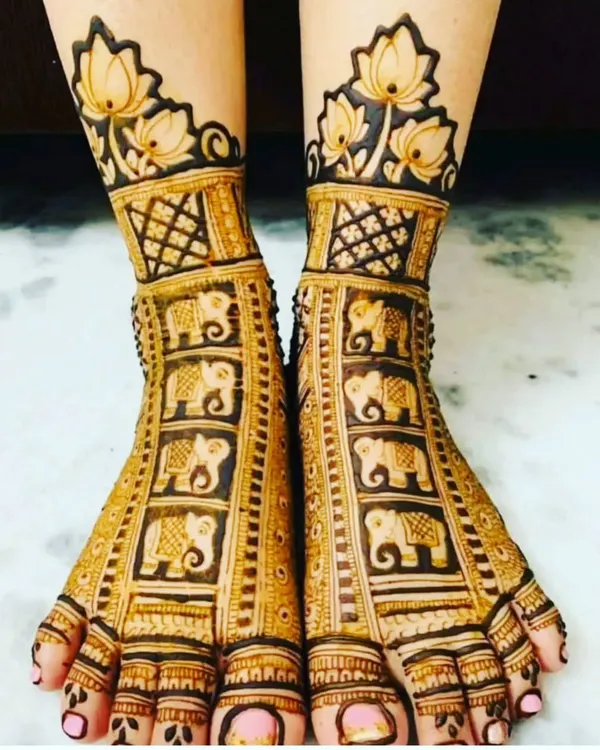 A classic leg mehendi design featuring rows of elephants. The design is topped with a beautiful lotus border, making it perfect for a traditional bride.