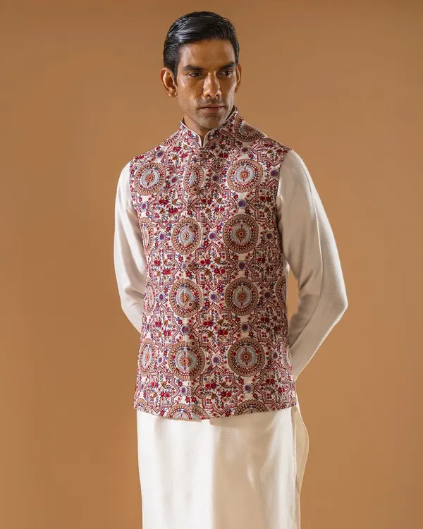 This Jawahar jacket is a masterpiece of dense, multi-colored embroidery, creating a rich tapestry of traditional motifs. Paired with a simple white kurta, it is a statement piece that speaks of heritage and artistry.