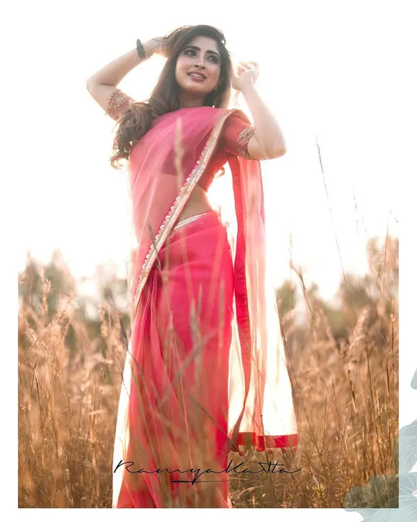 Celebrity Saanya Iyer in a calming orange-peach pure organza saree, hand-embroidered with beads and zardosi. A perfect picture of serene elegance in a sun-drenched field.