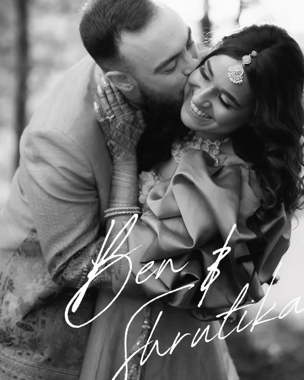 A classic, timeless black and white portrait. The focus is entirely on their emotional connection, his gentle kiss and her radiant smile. This is the kind of image that never goes out of style.