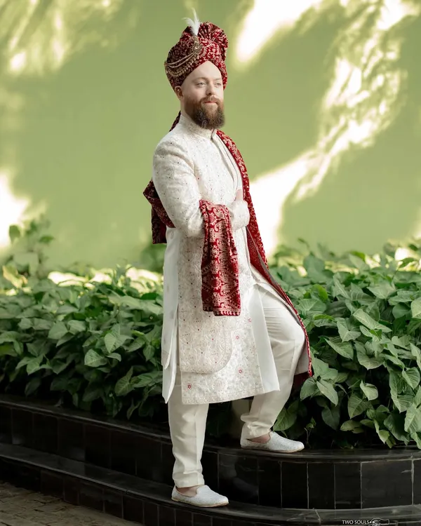 A strong and stylish portrait of the groom in his wedding sherwani. The confident pose and clean background highlight his regal attire and readiness for the big day.