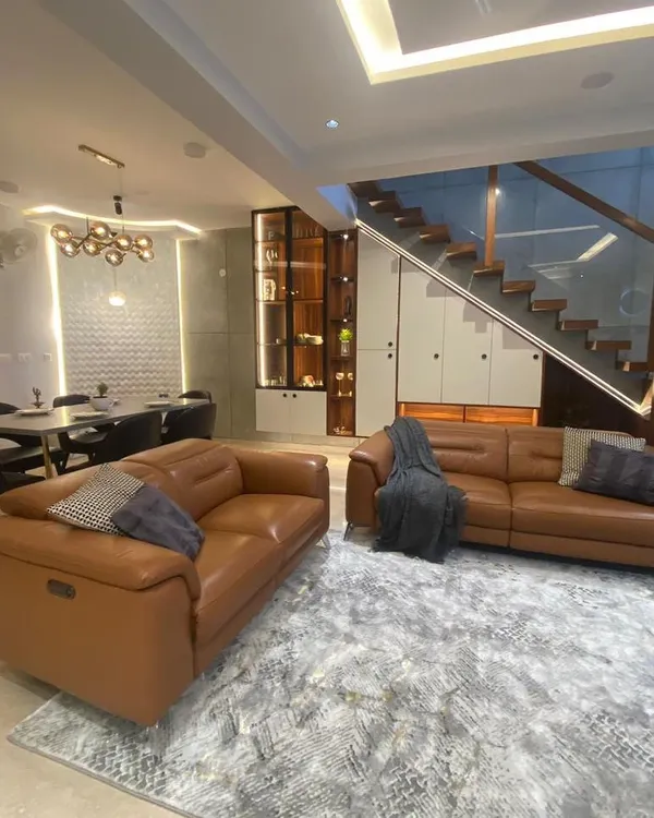 This open-plan living space showcases how I integrate different areas of the home, like the living, dining, and staircase, into one cohesive and luxurious design.