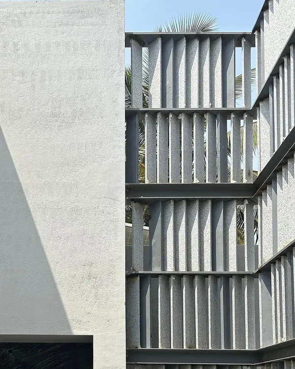 A work-in-progress shot of a west-facing facade. We designed this screen with angled stone fins to create a dynamic play of light throughout the day, while also providing shade and maintaining a connection to the street.