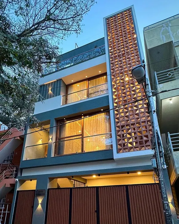 The facade of this compact Bengaluru home features a prominent terracotta jali screen. This element is not just decorative; it provides natural ventilation and privacy, making it a smart solution for urban living.
