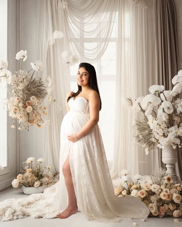 This is the magic I love to create in my studio. This gorgeous mom-to-be is surrounded by a dreamy floral setup, wearing a beautiful white lace gown that perfectly accentuates her glow. This fine-art pregnancy portrait is all about elegance and serenity.