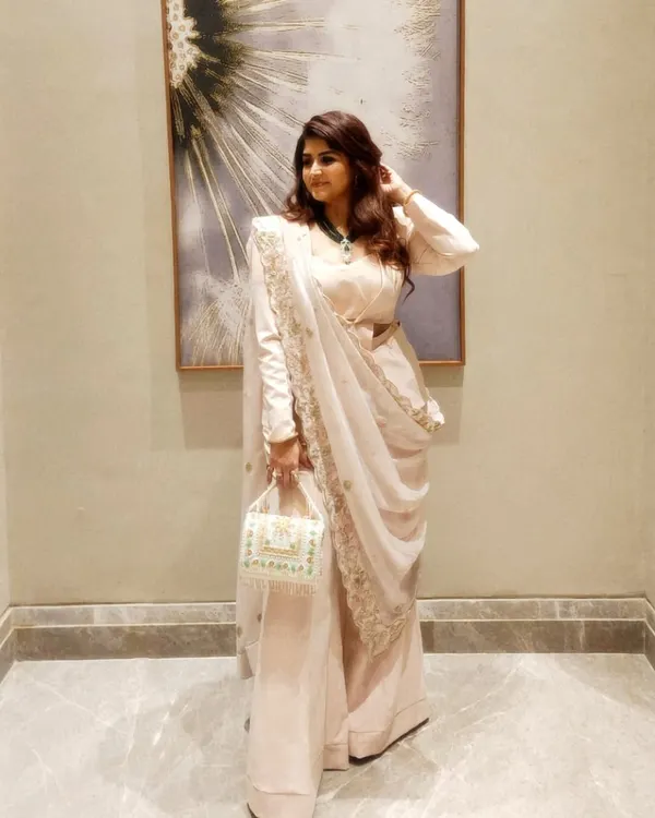 A full view of the powder peach powersuit with a zardozi dupatta. This Indo-Western ensemble is perfect for weddings or festive events, combining the structure of a suit with the grace of Indian embroidery.